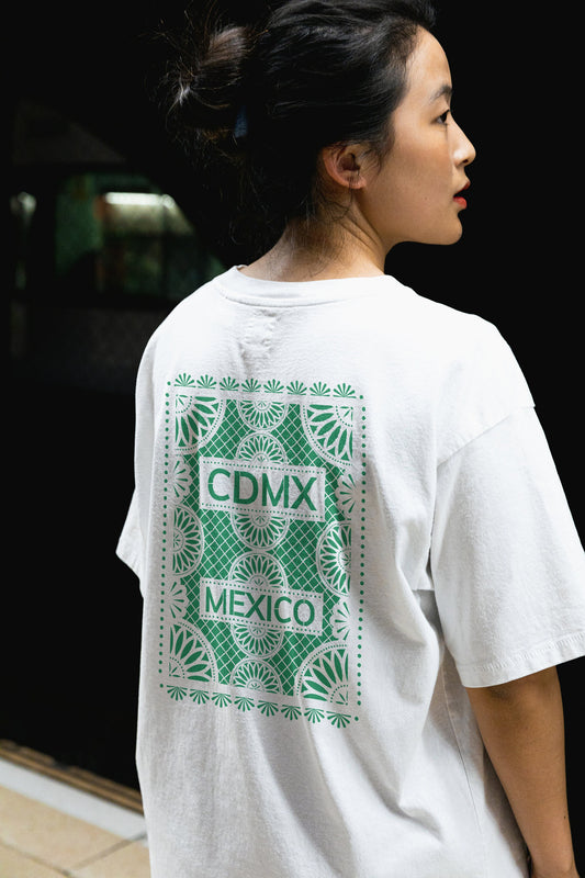 Back view of Unisex White Crewneck T-Shirt featuring green Papel Picado CDMX Mexico design on woman model