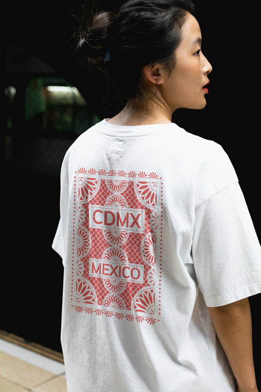 Back view of Unisex White Crewneck T-Shirt featuring red Papel Picado CDMX Mexico design - woman model