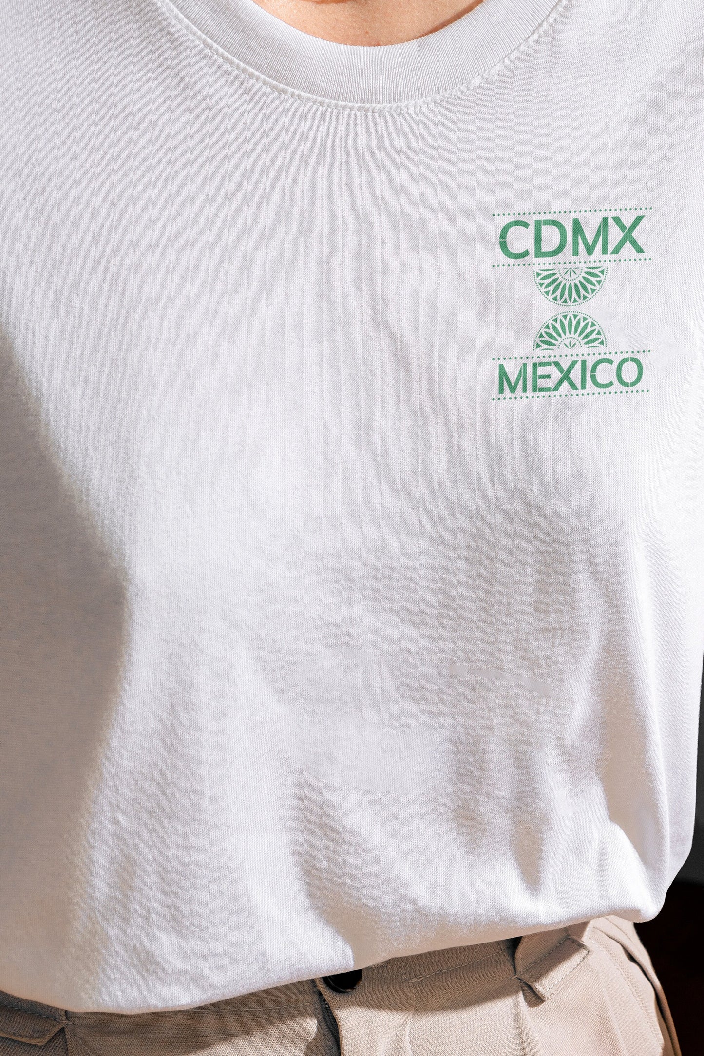 Front view of Unisex White Crewneck T-Shirt featuring green Papel Picado CDMX Mexico design on model
