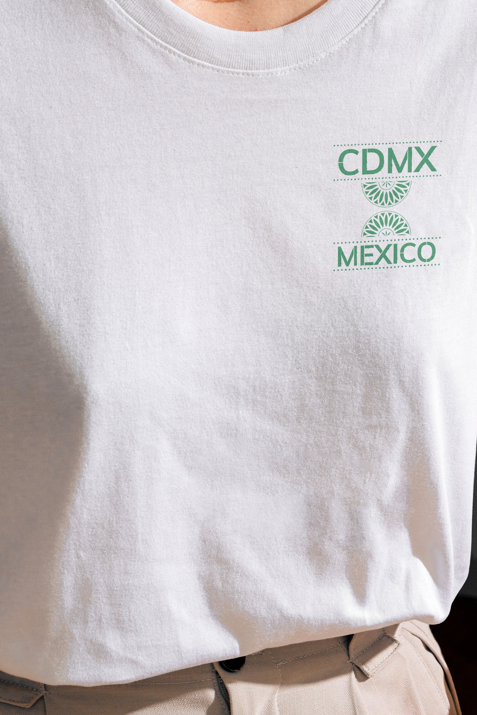 Front view of Unisex White Crewneck T-Shirt featuring green Papel Picado CDMX Mexico design on model
